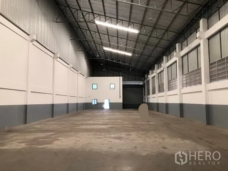 工厂 出租或出售在Bang Phli, Samut Prakan - 库房视角朝向装卸卷闸门，尽头设内部办公区。