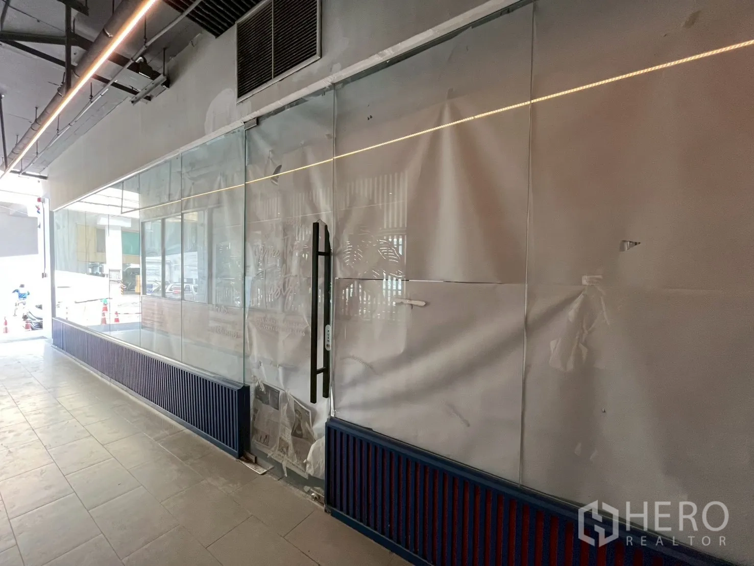 พื้นที่ขายของ for rent in Watthana, Bangkok - ผนังกระจกเต็มความสูงต่อเนื่องพร้อมมือจับ ทางเดินกว้างในอาคาร พื้นกระเบื้อง เพดานเปิดโล่งมีไฟเส้นและช่องแอร์