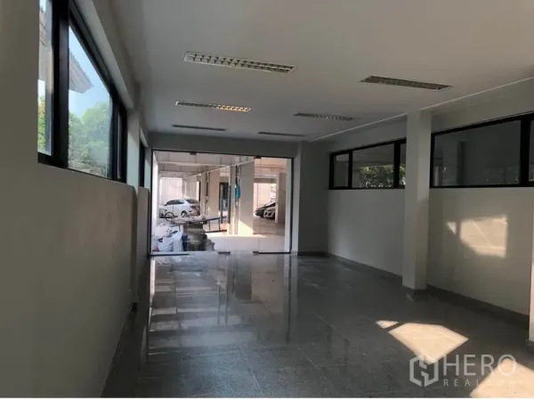 Office Space for rent in Khlong Toei, Bangkok - Bright office corridor with glass partitions opening toward a covered car park.