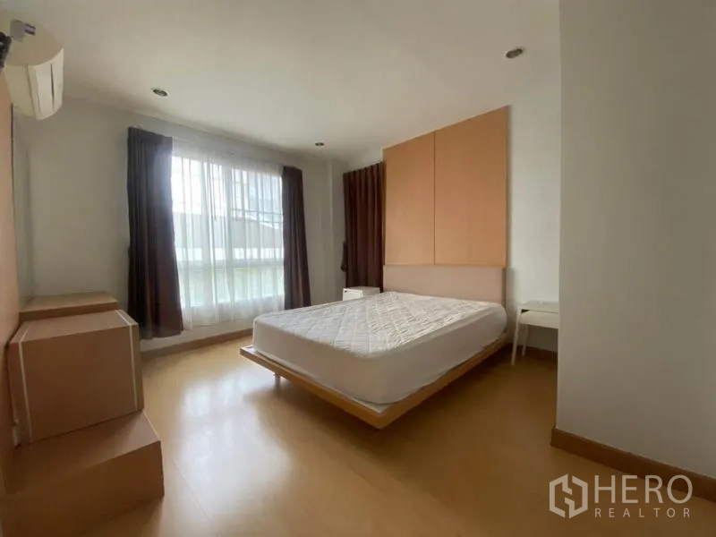 公寓 出租在Watthana, Bangkok - 主卧空间宽敞，配大床、落地窗、遮光窗帘与木地板。