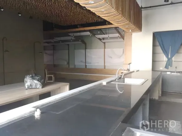 Retail Space for rent in Khlong Toei, Bangkok - Long black countertop with sink facing an open dining area, high ceiling, and decorative ceiling feature.