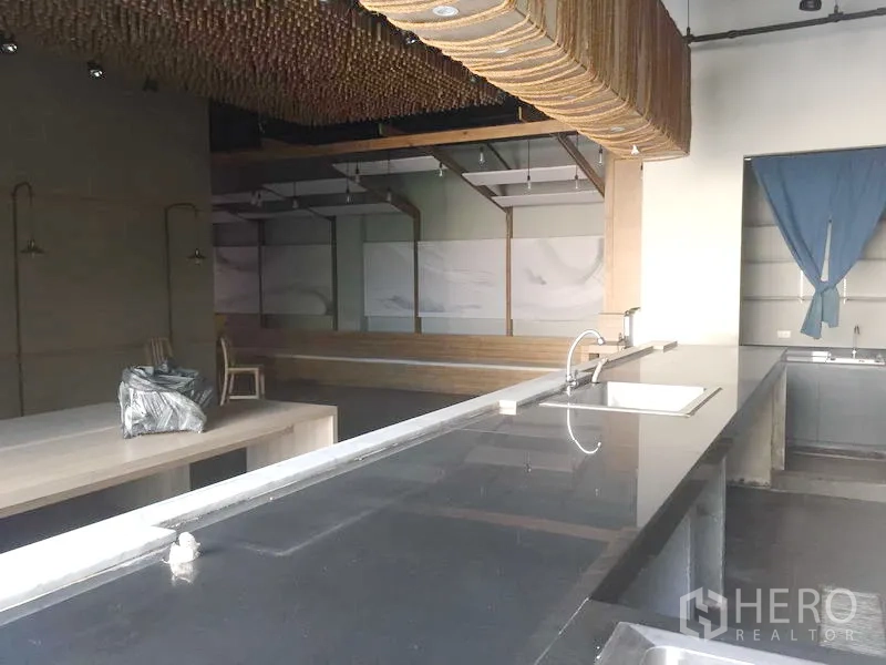 Retail Space for rent in Khlong Toei, Bangkok - Long black countertop with sink facing an open dining area, high ceiling, and decorative ceiling feature.