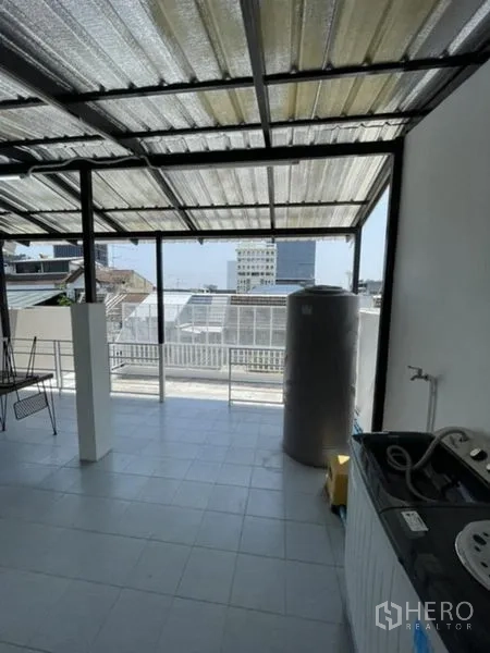 联排别墅 出租在Phra Khanong, Bangkok - 覆盖式屋顶露台，城市景观与水塔，适合洗衣晾晒。