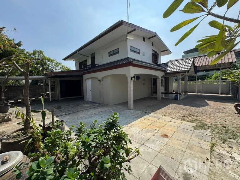 Detached House for rent in Wang Thonglang, Bangkok - Exterior view of the home showing the expansive paved yard and garden space.