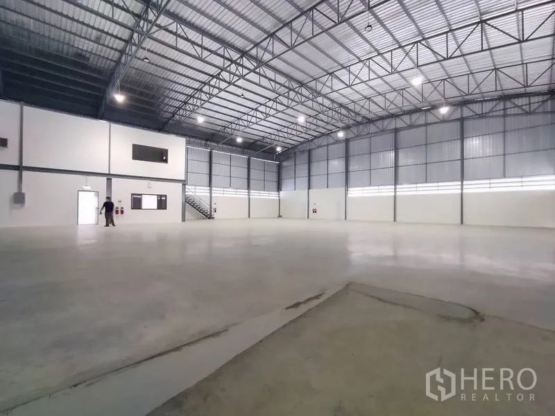 คลังสินค้า ให้เช่าในBang Phli, Samut Prakan - มุมมองภายในเห็นช่องแสงสูง ไฟสว่าง ประตูหนีไฟ และบันไดขึ้นออฟฟิศ.