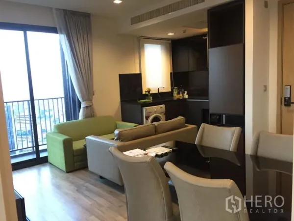 公寓 出租在Chatuchak, Bangkok - 开放式客餐厅连接阳台，配沙发与一体化小厨房及洗衣机。