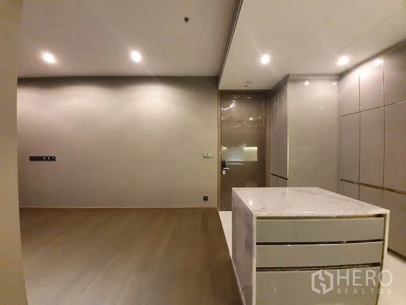 คอนโด ให้เช่าในHuai Khwang, Bangkok - โซนรับประทานอาหาร–นั่งเล่นข้างเกาะครัว พื้นไม้และไฟสปอตไลท์