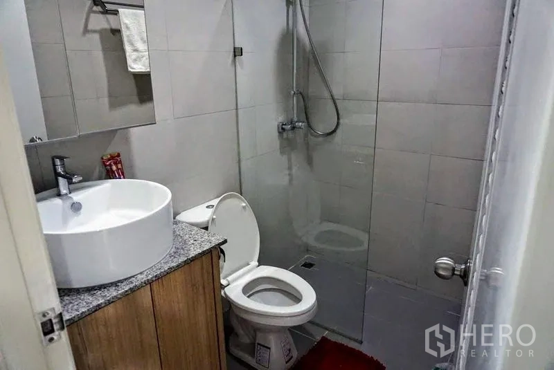 Shophouse for sale in Phra Khanong, Bangkok - Modern bathroom featuring a walk-in shower, glass screen, round basin and tiled walls.