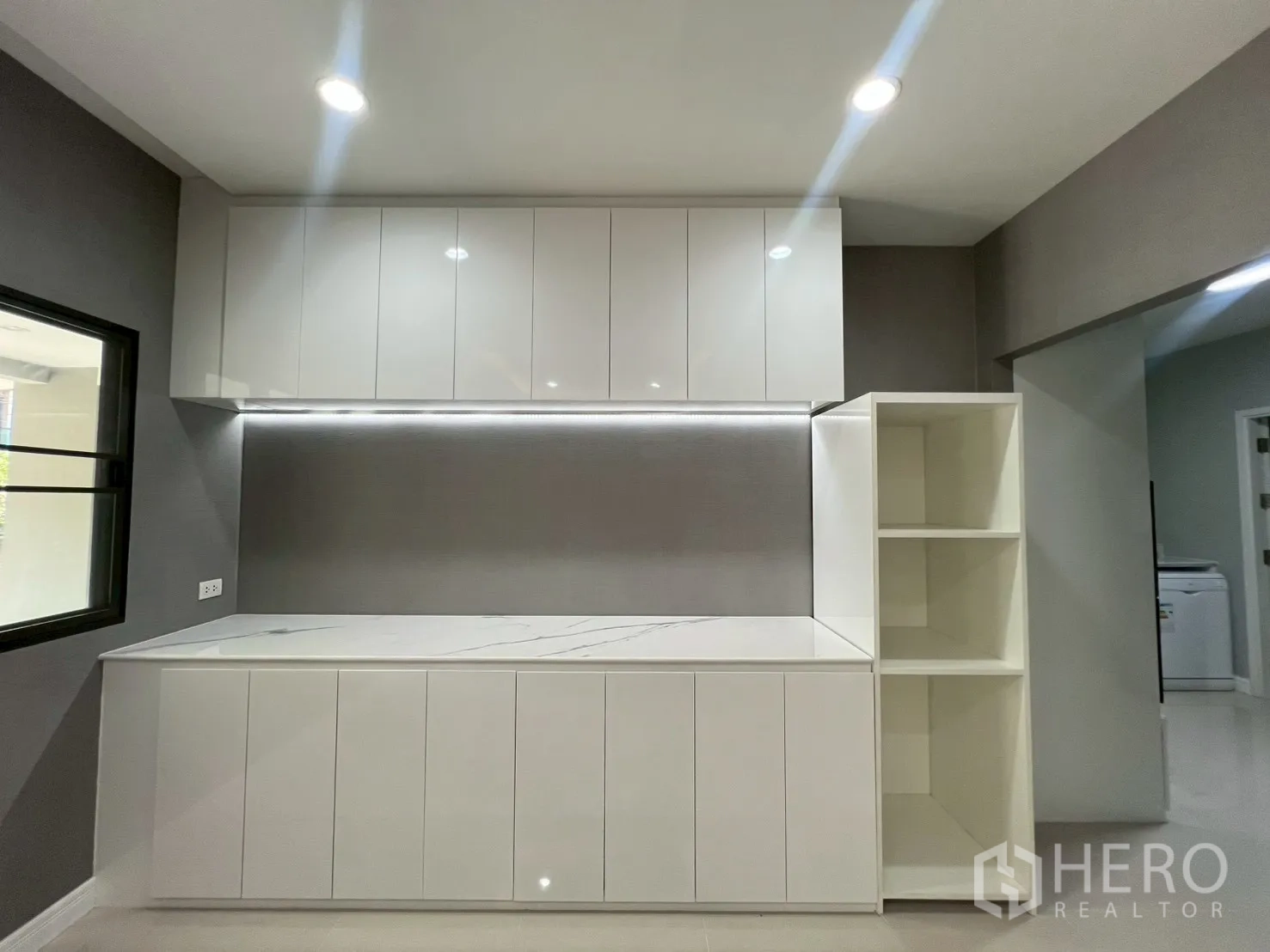 独立式住宅 出租或出售在Bang Phli, Samut Prakan - 极简白色厨房，仿石台面与大量柜体。