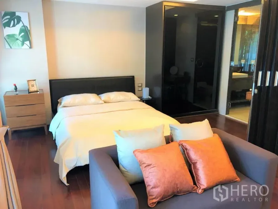 คอนโด ให้เช่าในWatthana, Bangkok - ห้องนอนสว่าง เตียงควีน โซฟาสองที่นั่ง และทางเข้าไปยังห้องน้ำแบบบานเลื่อน