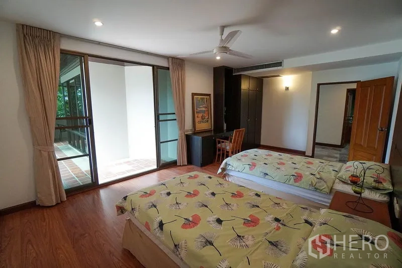 Apartment for rent in Watthana, Bangkok - Twin bedroom with built-in wardrobe, study nook, and access to a covered balcony.