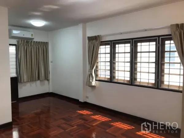 独立式住宅 出租在Khlong Toei, Bangkok - 采光充足的房间，拼花木地板，多扇带防护栏的窗户与空调