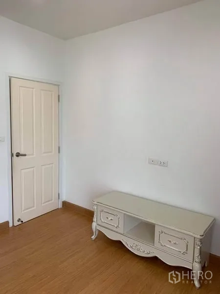 Detached House for sale in Suan Luang, Bangkok - Compact room with white vintage TV console and a paneled door.