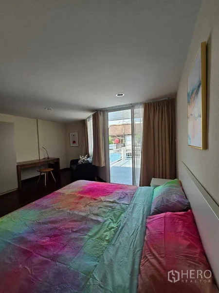 联排别墅 出租在Bang Na, Bangkok - 床对着阳台移门，整面窗帘与充足自然光。