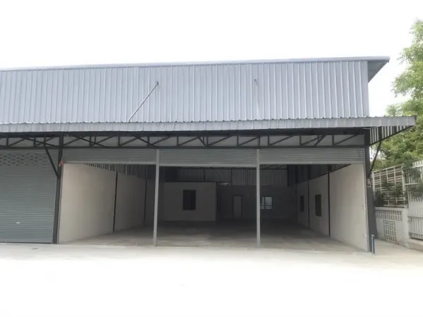 Warehouse for rent in Pathum Thani - Steel-clad warehouse exterior with wide covered loading bay and roller shutter in Khu Khot, Lam Luk Ka.