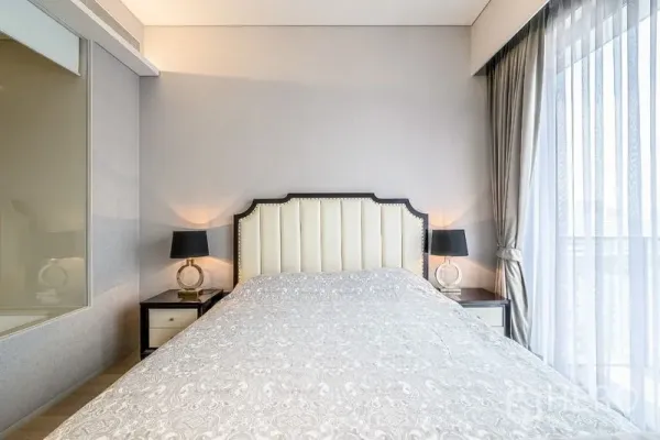 คอนโด ขายในWatthana, Bangkok - ห้องนอนโทนสว่าง หัวเตียงบุผ้า โต๊ะข้างเตียง และม่านโปร่งรับแสงธรรมชาติ