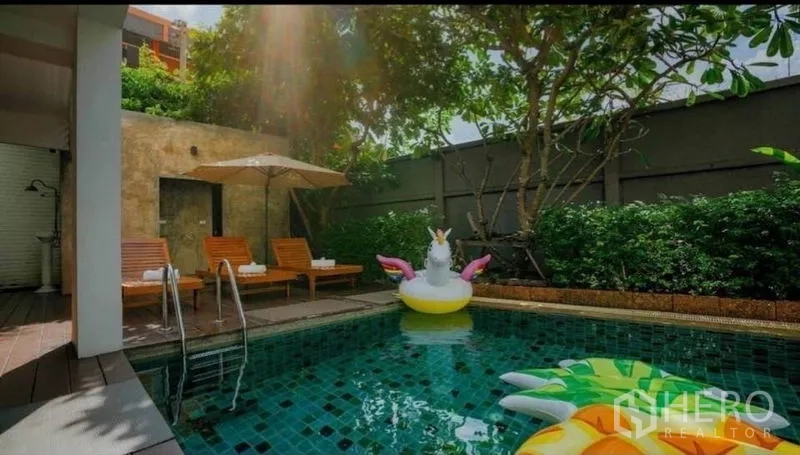 Retail Space for sale in Phra Nakhon, Bangkok - Shaded outdoor swimming pool with sun loungers, umbrellas and garden wall at a retail hospitality complex.