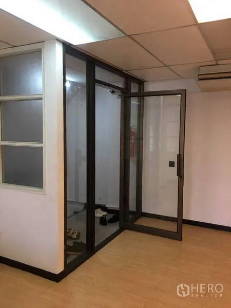 办公空间 出租在Bang Na, Bangkok - 玻璃隔断会议室，推拉门、木纹地板与吊顶照明。
