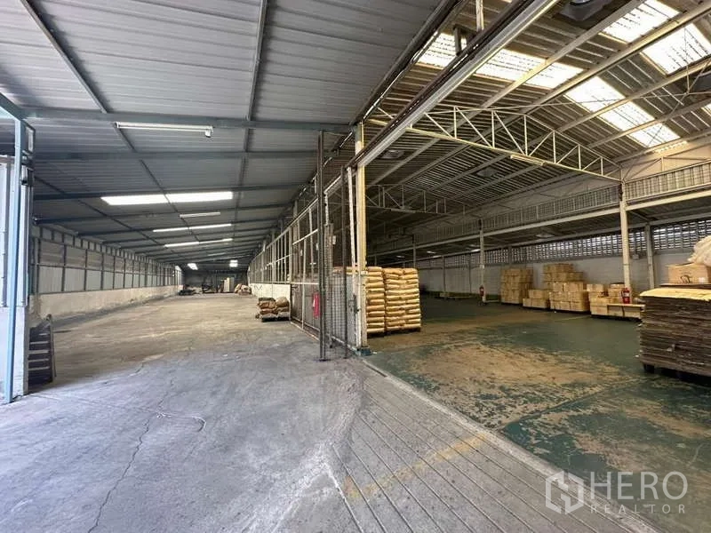 货栈 出租在Yan Nawa, Bangkok - 宽敞的仓库内部，高挑钢架屋顶与天窗，宽阔装卸区，侧旁堆放托盘。