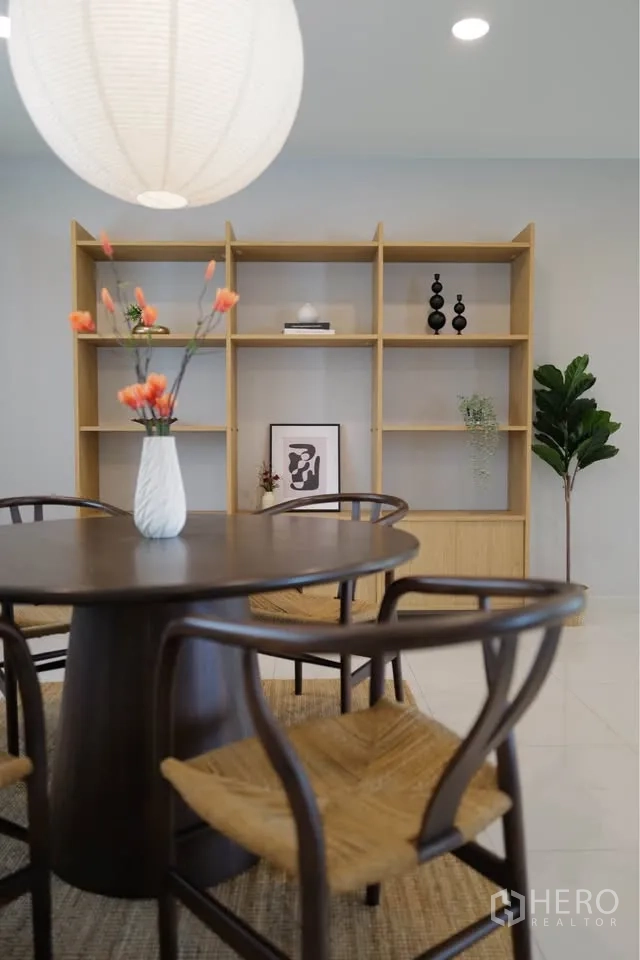 Detached House for rent or sale in Bang Phli, Samut Prakan - Dining close-up showing round table, woven chairs, and built-in display shelves.