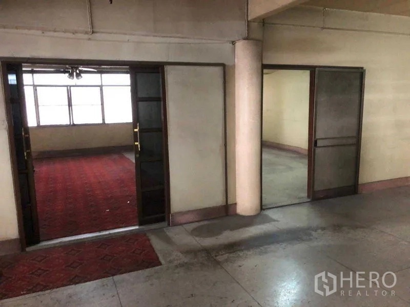 Shophouse for rent in Khlong Toei, Bangkok - Hallway with double doors opening to rooms, one featuring red carpet flooring.