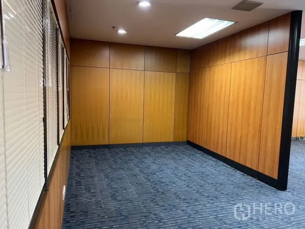 Office Space for rent - Private meeting room with wood partition walls, blue carpet tiles, and downlights.