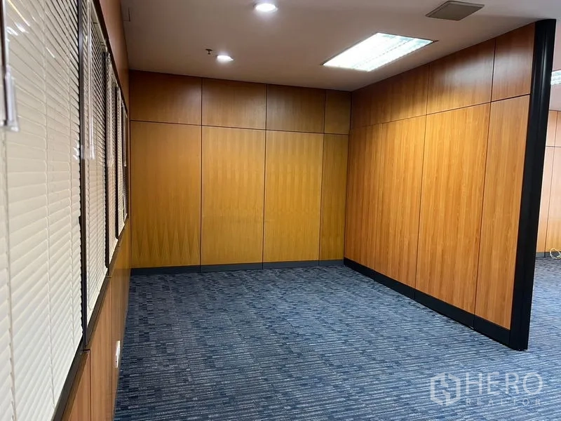 Office Space for rent - Private meeting room with wood partition walls, blue carpet tiles, and downlights.