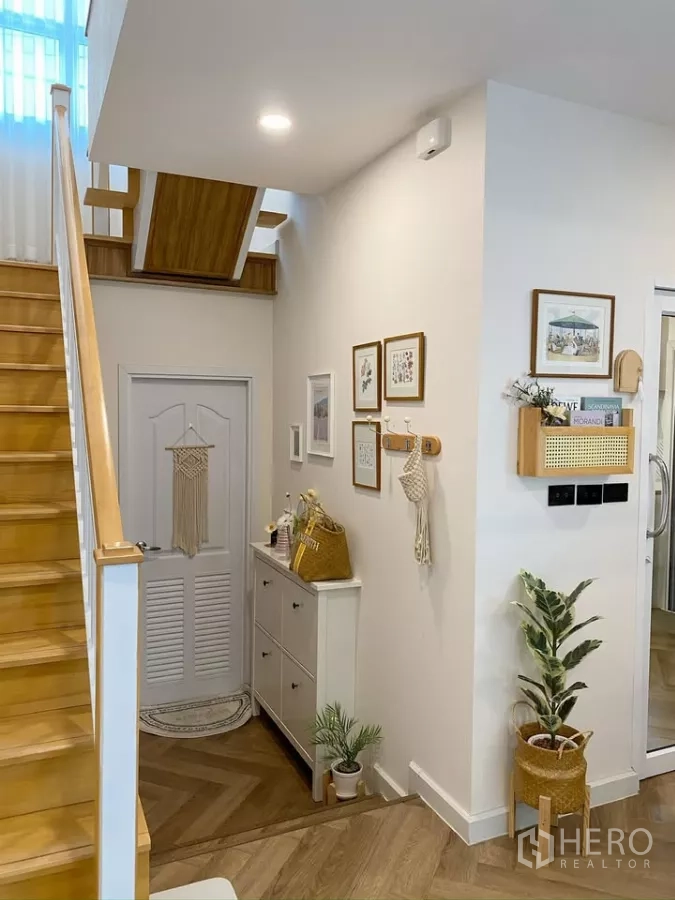 Detached House for sale in Sai Mai, Bangkok - Entrance hall with warm wooden staircase and decorative console.
