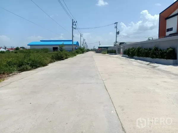 โรงงาน ให้เช่าหรือขายในMueang Samut Sakhon, Samut Sakhon - ถนนอุตสาหกรรมคอนกรีตกว้าง มีเสาไฟฟ้าและกำแพงจัดสวนหน้าโรงงาน