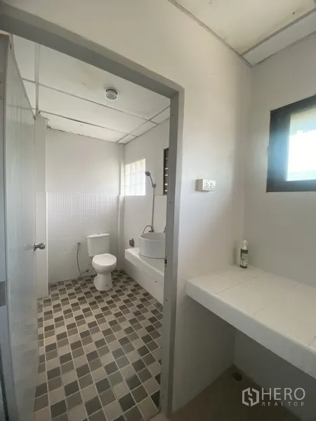 Townhouse for rent in Suan Luang, Bangkok - Clean bathroom with vanity, shower and toilet, tiled in neutral tones.