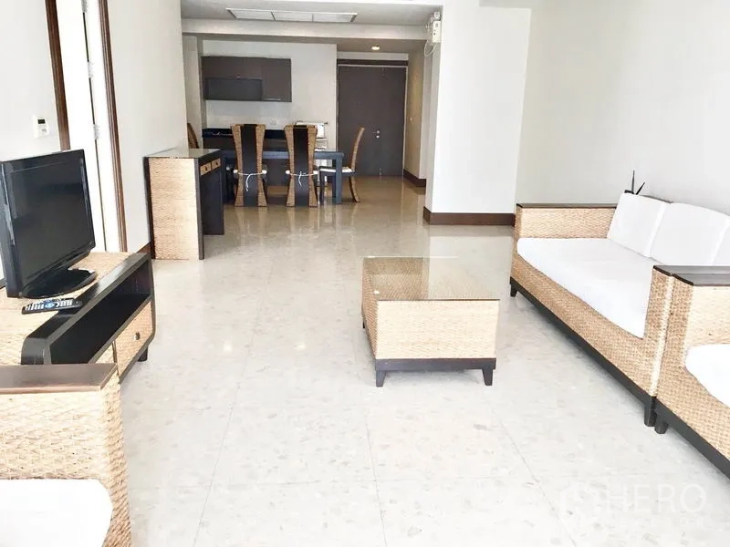 公寓 出租在Khlong Toei, Bangkok - 宽敞客餐厅一体，藤编家具与亮面地砖。