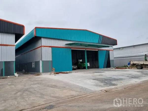 货栈 出租在Saphan Sung, Bangkok - 曼谷沙攀颂区现代仓库外观，青灰色金属墙体，宽阔装卸场与高大滑门。