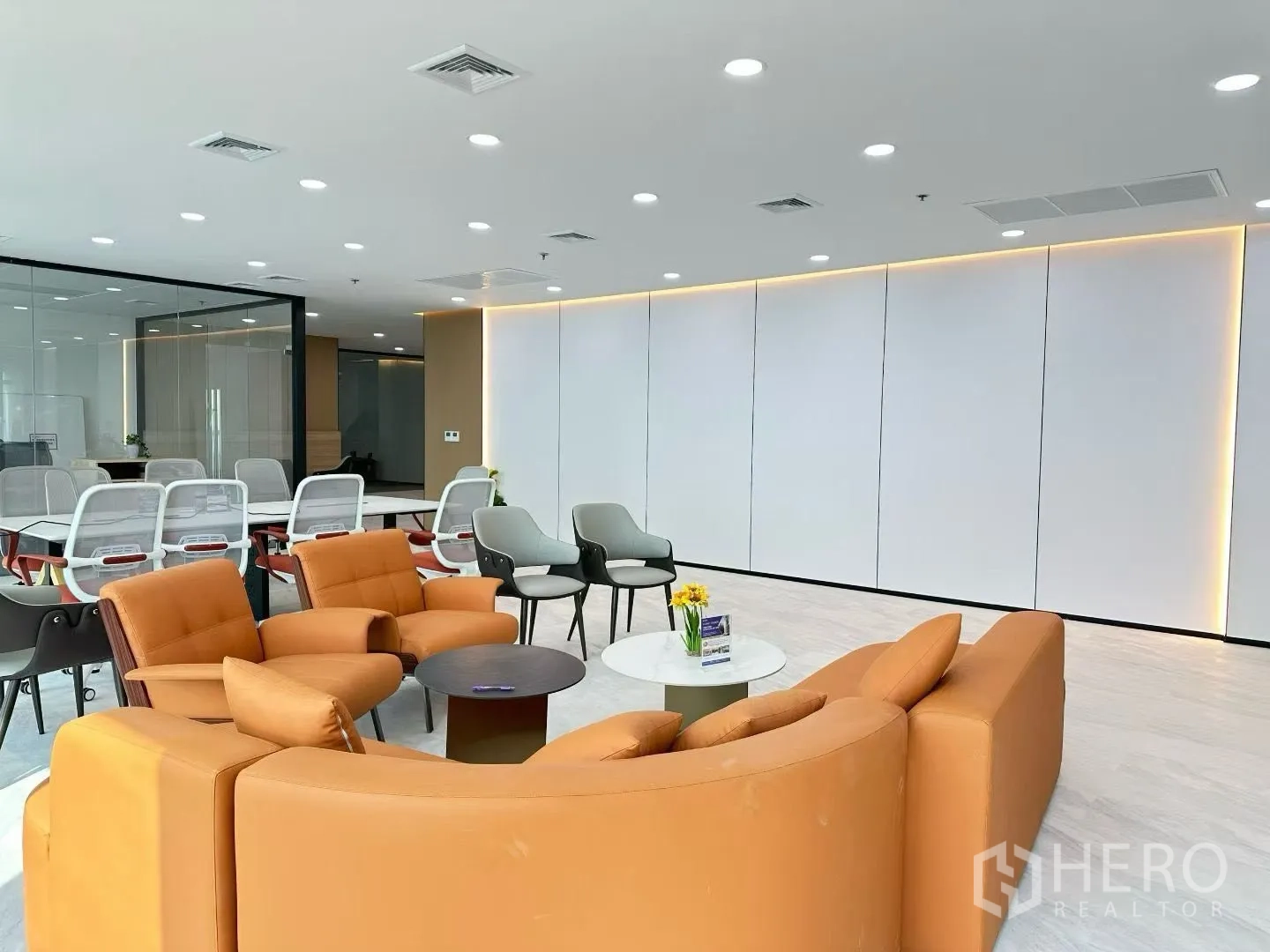 Office Space for rent in Huai Khwang, Bangkok - Cozy lounge seating facing a glass meeting room with warm recessed lighting.