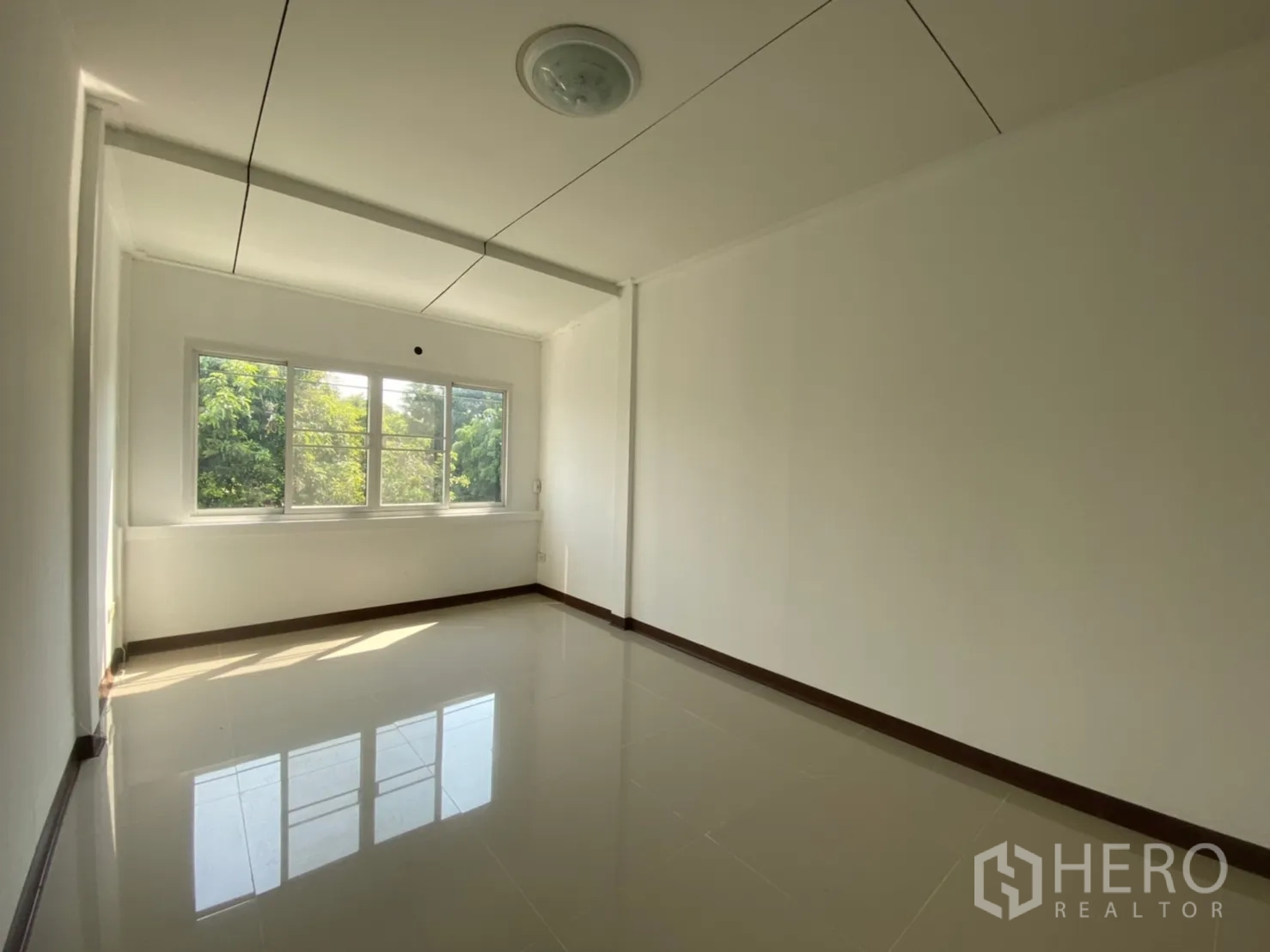 Townhouse for rent in Watthana, Bangkok - Spacious bedroom with wide window offering leafy green views.