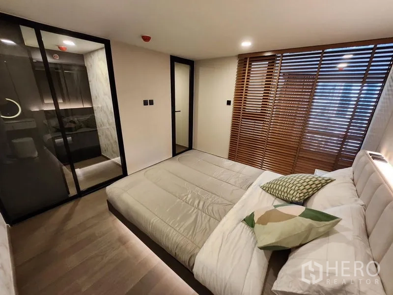 Condominium for rent - Mezzanine bedroom with sliding glass wardrobe and wooden louver screens.