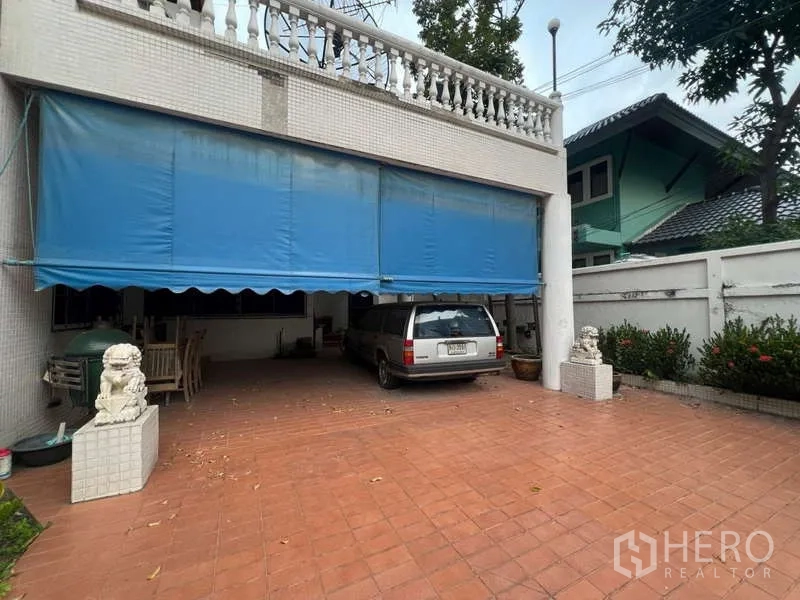 บ้าน ขายในPhra Khanong, Bangkok - ที่จอดรถในร่ม มีกันสาดสีน้ำเงินและพื้นกระเบื้อง รองรับหลายคัน