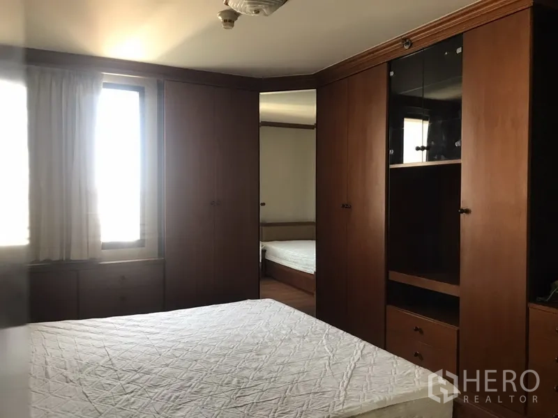 公寓 出租在Watthana, Bangkok - 卧室四周衣柜，窗户引入自然光。
