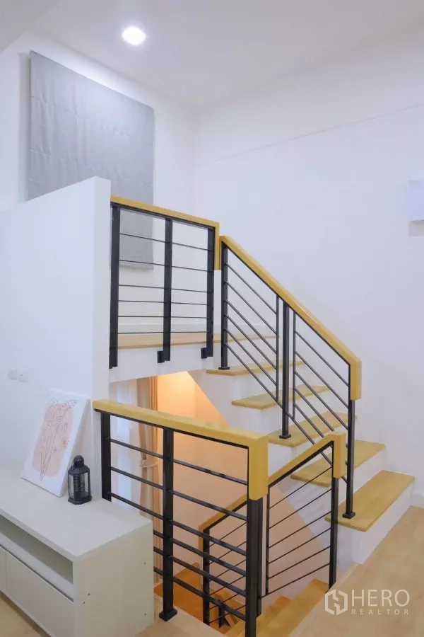 独立式住宅 出租在Bang Phli, Samut Prakan - 现代楼梯，黑色金属栏杆与木质踏步。