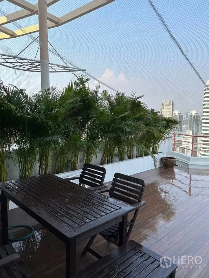 公寓 出租或出售在Yan Nawa, Bangkok - 露台户外餐桌椅，两侧绿植成排，远眺城市。