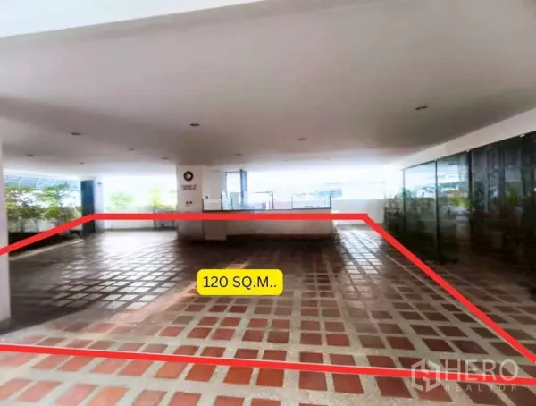 零售空间 出租在Watthana, Bangkok - 以红线标注的120平米区域，明亮的覆盖平台，右侧为玻璃墙与绿化。