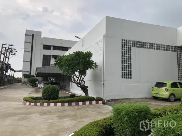 工厂 出租在Lat Krabang, Bangkok - 工厂外观，白色建筑、车道与修剪整齐的绿化
