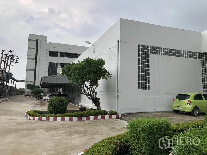 工厂 出租在Lat Krabang, Bangkok - 工厂外观，白色建筑、车道与修剪整齐的绿化