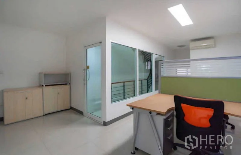 Home Office for rent or sale in Lat Krabang, Bangkok - Office corner with storage cabinet beside glass-walled stairwell.