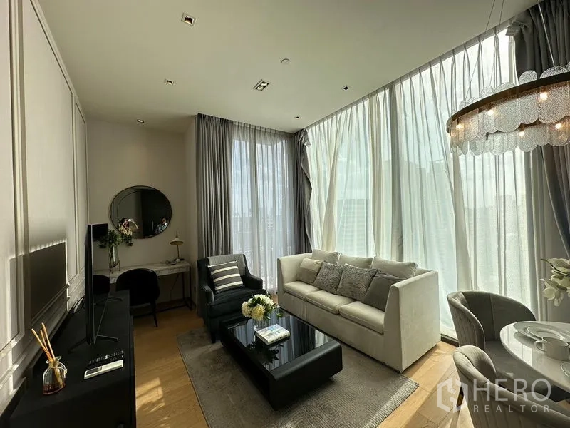 公寓 出租在Pathum Wan, Bangkok - 开放式客厅，落地窗与薄纱窗帘，沙发区采光充足。