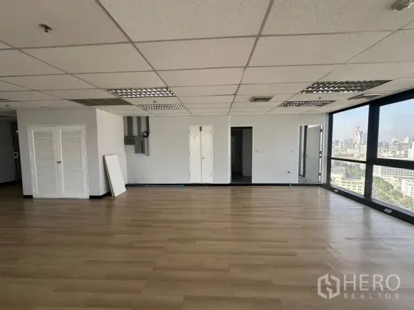 Office Space for rent in Bang Rak, Bangkok - Spacious office interior with large windows, city views and doorways suitable for meeting rooms.