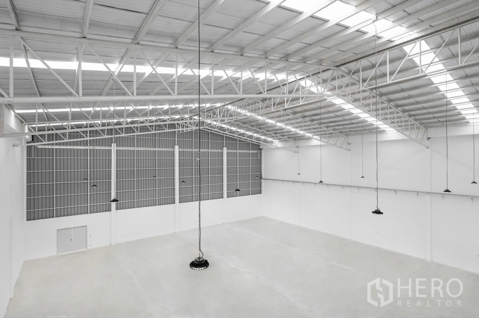 Factory for rent in Pathum Thani - Overhead perspective of the steel roof structure and hanging LED lights.