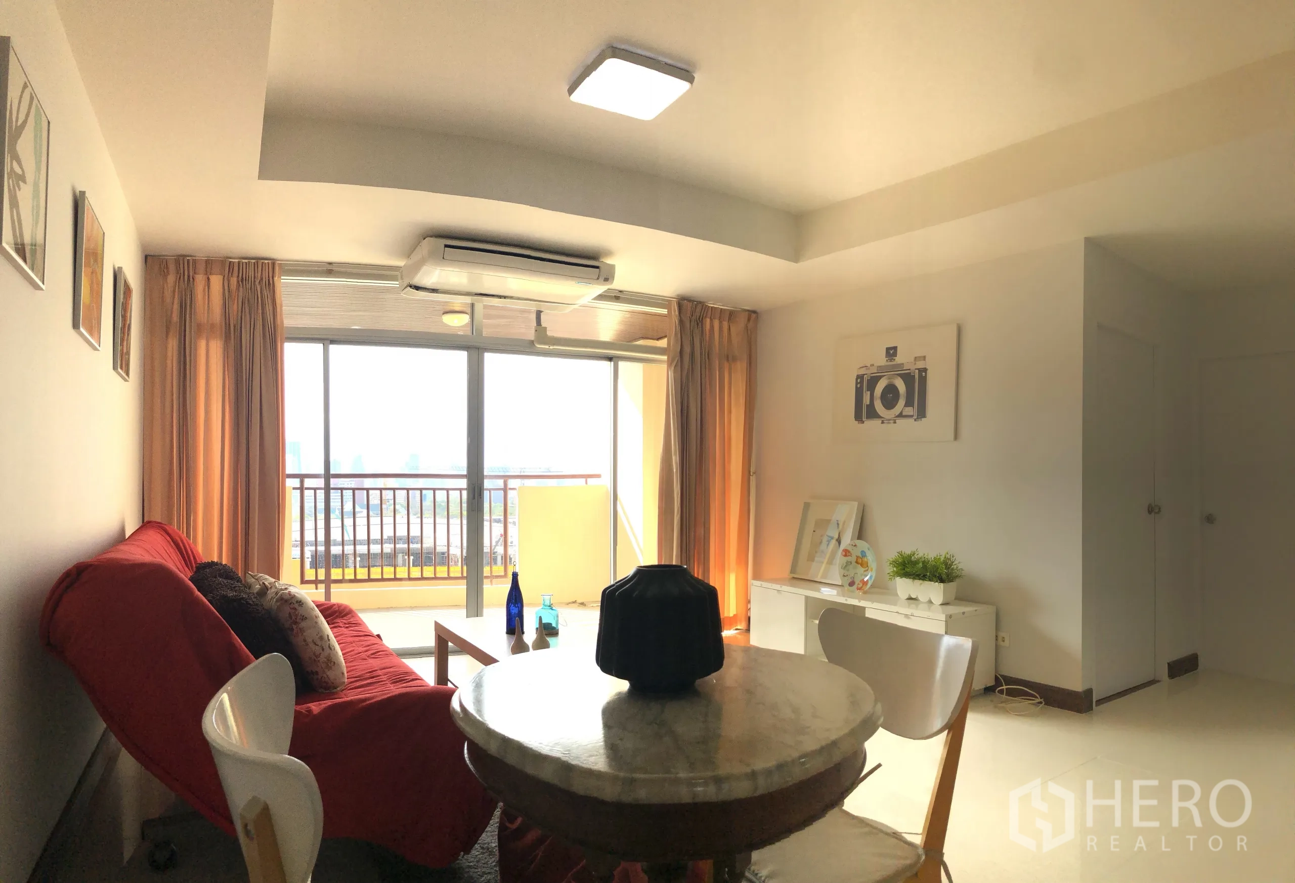คอนโด ให้เช่าหรือขายในKhlong Toei, Bangkok - ห้องนั่งเล่นสว่าง โซฟาสีแดง โต๊ะทานข้าว และประตูกระจกสไลด์ออกสู่ระเบียงวิวเมือง