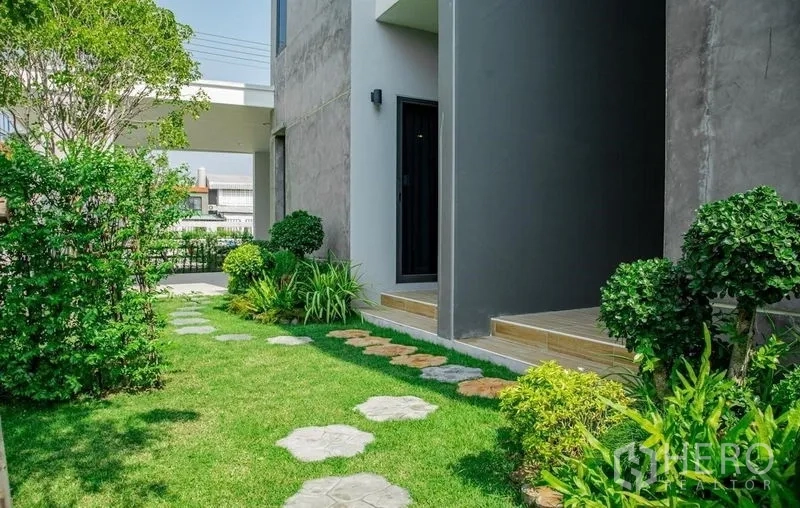 Detached House for sale in Lam Luk Ka, Pathum Thani - Private garden with stepping stones, manicured shrubs, and neat lawn.