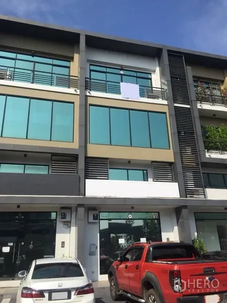 带办公室的家 出租或出售在Prawet, Bangkok - 曼谷Prawet区 H‑Cape 现代多层商住办公楼，大片镀膜玻璃立面，前方可停车。