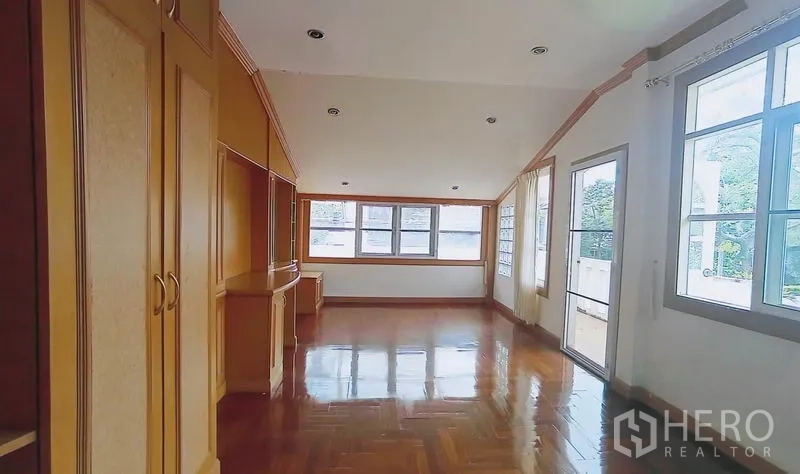 独立式住宅 出售在Bang Kapi, Bangkok - 宽敞家庭厅，木地板、内置柜，通向阳台的门。